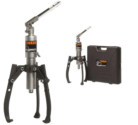 Obraz jest ucieleśnieniem mobilności, wygody i amerykańskiej solidności w dziedzinie narzędzi warsztatowych. Kompozycja prezentuje ściągacz hydrauliczny ze zintegrowaną pompą (seria TIMKEN Integrated/VHPT) jako kompaktowe, samowystarczalne narzędzie "wszystko w jednym". Całość osadzona jest w kontekście autoryzowanego polskiego dystrybutora DAKAM, podkreślając dostępność profesjonalnych rozwiązań. W centrum uwagi, na czystej powierzchni warsztatowej, znajduje się kompaktowy ściągacz hydrauliczny TIMKEN: &bull;	Konstrukcja "Wszystko w jednym": Najważniejszy element wizualny &ndash; brak zewnętrznych węży i pomp. Siłownik hydrauliczny i pompa ręczna stanowią jedną, zwartą całość. &bull;	Ergonomiczna dźwignia: Widoczna jest obrotowa dźwignia (rączka) pompy, kt&oacute;ra umożliwia pracę w dowolnej pozycji (360 stopni), co jest kluczową zaletą tego modelu. &bull;	Solidne ramiona: Trzy mocne, kute ramiona (szczęki) pewnie obejmujące demontowany element. Ich konstrukcja sugeruje bezpieczeństwo i brak poślizgu. &bull;	Zaw&oacute;r bezpieczeństwa: Na korpusie widoczny jest precyzyjny zaw&oacute;r spustowy/bezpieczeństwa, gwarantujący kontrolę nad procesem ściągania. &bull;	Marka Premium: Na korpusie urządzenia wyraźnie widoczne jest oryginalne logo "TIMKEN", co potwierdza klasę narzędzia. Obok może leżeć siatka ochronna (safety blanket), często dostarczana z tymi zestawami. Tło jest subtelnie rozmyte (efekt bokeh), ale jednoznacznie wskazuje na profesjonalne zaplecze: &bull;	Magazyn DAKAM: W tle widać regały z walizkami transportowymi (często wykonanymi z wytrzymałego tworzywa), w kt&oacute;rych te mobilne zestawy są przechowywane. &bull;	Logo Dystrybutora: W dyskretnym, ale widocznym miejscu umieszczone jest logo DAKAM, z dopiskiem "Autoryzowany Dystrybutor TIMKEN". Obraz niesie jasny komunikat: "Potrzebujesz mobilnego, silnego narzędzia do demontażu bez plątaniny węży? Zintegrowane ściągacze hydrauliczne TIMKEN, dostępne w DAKAM, to idealne rozwiązanie dla serwisu mobilnego i utrzymania ruchu".