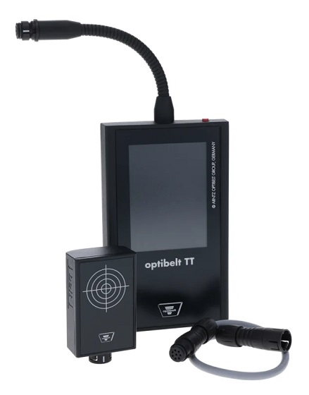 Na zdjęciu widoczne jest niewielkie, przenośne urządzenie z cyfrowym wyświetlaczem. Miernik jest w szaro-czerwonej obudowie, kt&oacute;ra jest ergonomiczna i wygodna w trzymaniu.  Na g&oacute;rnej części urządzenia znajduje się mikrofon, kt&oacute;ry służy do pomiaru częstotliwości drgań pasa. Poniżej znajduje się wyświetlacz LCD, na kt&oacute;rym wyświetlane są wyniki pomiar&oacute;w w hercach (Hz) oraz inne komunikaty. Obok wyświetlacza widać przyciski do obsługi urządzenia, takie jak włącznik, czy przyciski do nawigacji po menu.  Na obudowie urządzenia, tuż pod wyświetlaczem, wyraźnie widoczne jest logo producenta, OPTIBELT, oraz nazwa modelu, OPTI-TT TT. Zdjęcie może przedstawiać miernik w dłoni, co podkreśla jego mobilność, lub położony na stole, gotowy do użycia.