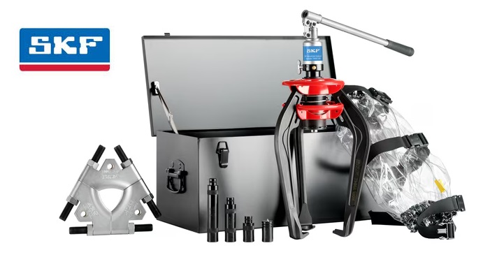 Kompletny Zestaw Heavy Duty SKF TMMA 100H/SET w DAKAM Obraz jest ucieleśnieniem wszechstronności w wadze ciężkiej. Prezentuje najpotężniejszy zestaw w ofercie SKF &ndash; TMMA 100H/SET &ndash; jako ostateczne rozwiązanie dla służb utrzymania ruchu. Kompozycja łączy surową siłę 10-tonowego ściągacza z precyzją akcesori&oacute;w, zamkniętych w profesjonalnej walizce. Całość osadzona jest w kontekście autoryzowanego polskiego dystrybutora DAKAM, gwarantującego dostępność tych specjalistycznych narzędzi. Dominują barwy: czerń (ściągacz), solidna stal (płyty) oraz metaliczna szarość walizki. 10 ton siły z pełnym osprzętem: W centrum uwagi, na wzmocnionym stole warsztatowym, znajduje się otwarta, duża metalowa walizka, prezentująca imponującą zawartość zestawu SKF TMMA 100H/SET: &bull;	Ściągacz Hydrauliczny (TMMA 100H): Centralny element. Widoczny jest masywny, czarny korpus najsilniejszego zintegrowanego ściągacza (100 kN). Jego rozmiar dominuje nad resztą element&oacute;w, obiecując bezkompromisową siłę. &bull;	Płyta do Odklejania (TMMS 160): Kluczowy element zestawu. Obok ściągacza (lub zamontowana na nim) widoczna jest duża, tr&oacute;jdzielna płyta stalowa. Jej masywna konstrukcja i ostre krawędzie wizualnie komunikują możliwość uchwycenia dużych łożysk osadzonych "na płasko", tam gdzie tradycyjne ramiona nie mają dostępu. &bull;	Przedłużki Ramion: W dedykowanych gniazdach walizki lśnią długie, stalowe przedłużki, kt&oacute;re pozwalają na zwiększenie zasięgu narzędzia, umożliwiając pracę przy głęboko osadzonych elementach. &bull;	Koc Ochronny: Widoczny zwinięty koc ochronny, przypominający o standardach BHP przy pracy z tak dużymi siłami. &bull;	Organizacja: Ujęcie podkreśla, że mimo dużej wagi element&oacute;w, wszystko ma swoje miejsce, co ułatwia transport na miejsce awarii. Sprawdzony Polski Dystrybutor DAKAM: Tło jest subtelnie rozmyte, ale buduje autorytet dostawcy: &bull;	Strefa Heavy Duty: W tle widać fragment magazynu z dużymi łożyskami lub ciężkimi elementami maszyn, co tworzy naturalne środowisko dla tego typu narzędzi. &bull;	Dostępność: Widoczne zamknięte walizki na palecie sugerują, że DAKAM posiada te zestawy na stanie, gotowe do natychmiastowej wysyłki. &bull;	Logo Dystrybutora: W dyskretnym, ale widocznym miejscu umieszczone jest logo DAKAM, z dopiskiem "Autoryzowany Dystrybutor Narzędzi SKF". Obraz niesie jasny komunikat: "W DAKAM oferujemy kompletne rozwiązanie do zadań specjalnych &ndash; zestaw SKF TMMA 100H/SET. To połączenie 10 ton siły hydraulicznej z tr&oacute;jdzielną płytą do odklejania, umożliwiające bezpieczny demontaż największych i najtrudniej dostępnych łożysk".