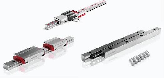Wysokoprecyzyjne komponenty do ruchu liniowego (Linear Motion Components) firmy SCHNEEBERGER. Centralny element to szczeg&oacute;łowy widok prowadnicy profilowej (np. MONORAIL), wykonanej z hartowanej stali. Widoczna jest szyna oraz w&oacute;zek jezdny z elementami tocznymi, zaprojektowane dla zapewnienia beztarciowego i precyzyjnego ruchu w maszynach. Kolory to gł&oacute;wnie metaliczna szarość i srebro, symbolizujące przemysłową dokładność i jakość.